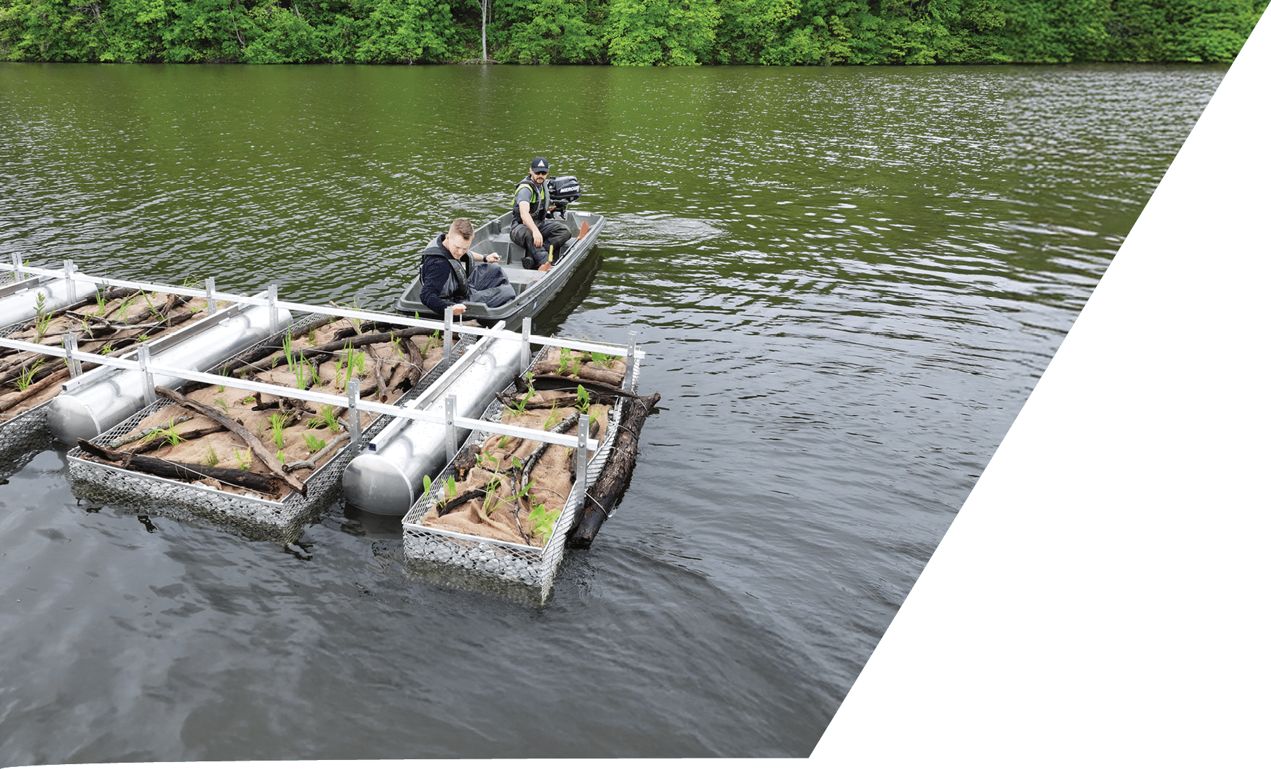Two men in a small motor boat installing a floating wetland at Fellows Lake
