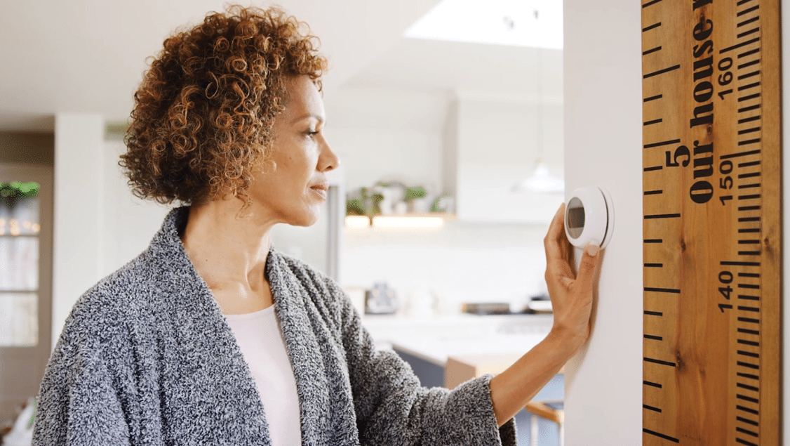 A woman is standing in a kitchen, looking at a ruler on the wall. AI generated content
